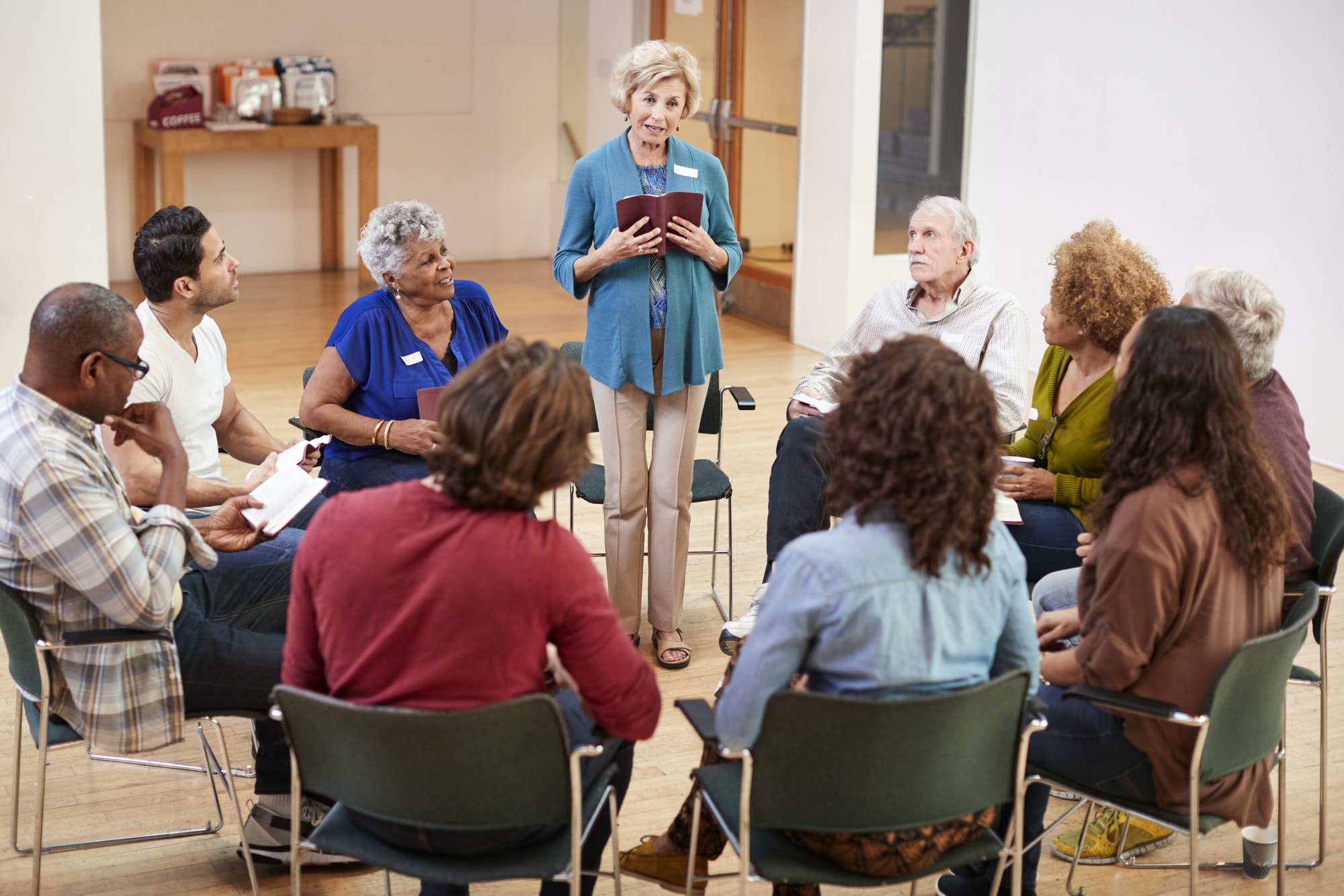 People Attending Bible Study Or Book Group Meeting In Community Center